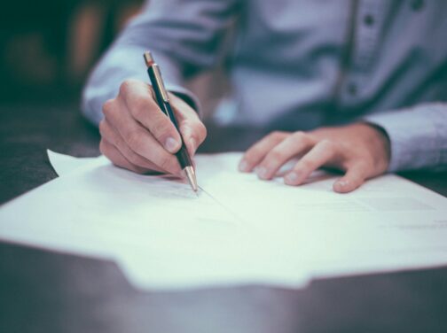 man writing on paper